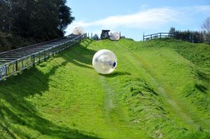 zorbing ball going down a field of grassy hill